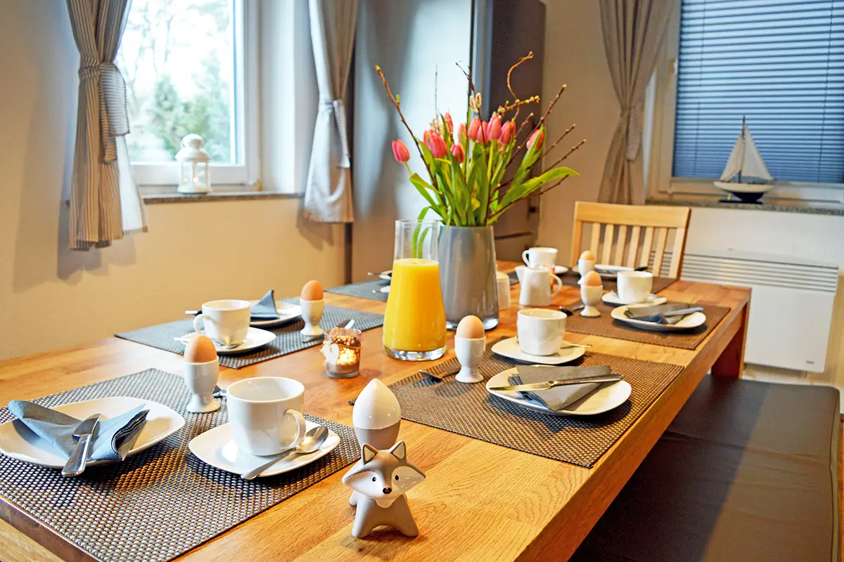 Frühstückstisch im Ferienhaus am Plauer See mit frischen Blumen, Kaffee und Saft