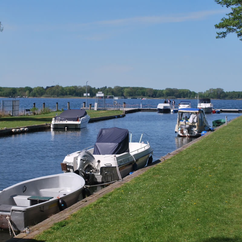 Bootsanleger am Plauer See mit Motorbooten und Yachten im Sonnenschein