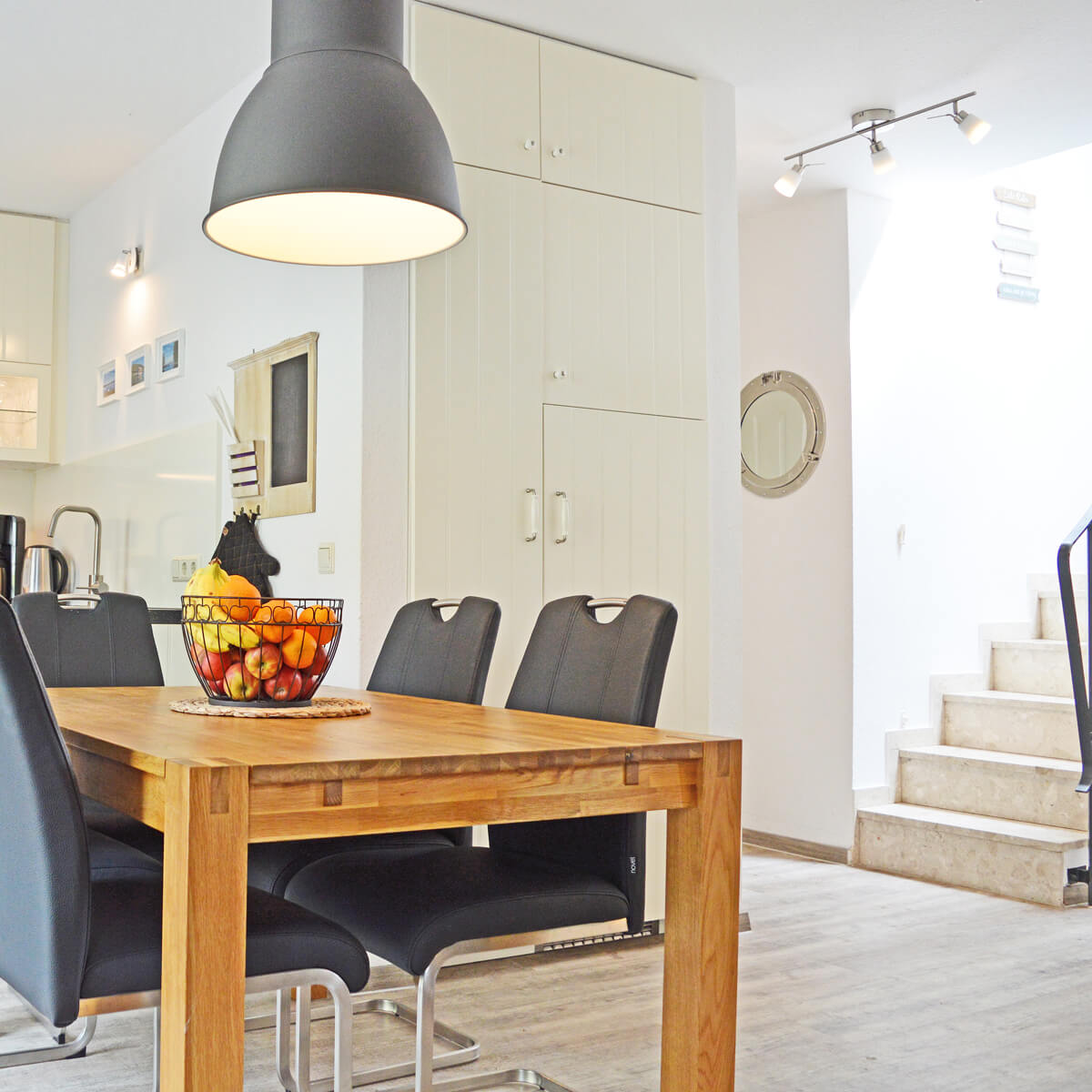 Heller Essbereich im Ferienhaus Fox Lenz mit Holztisch, modernen StĂĽhlen und frischem Obstkorb