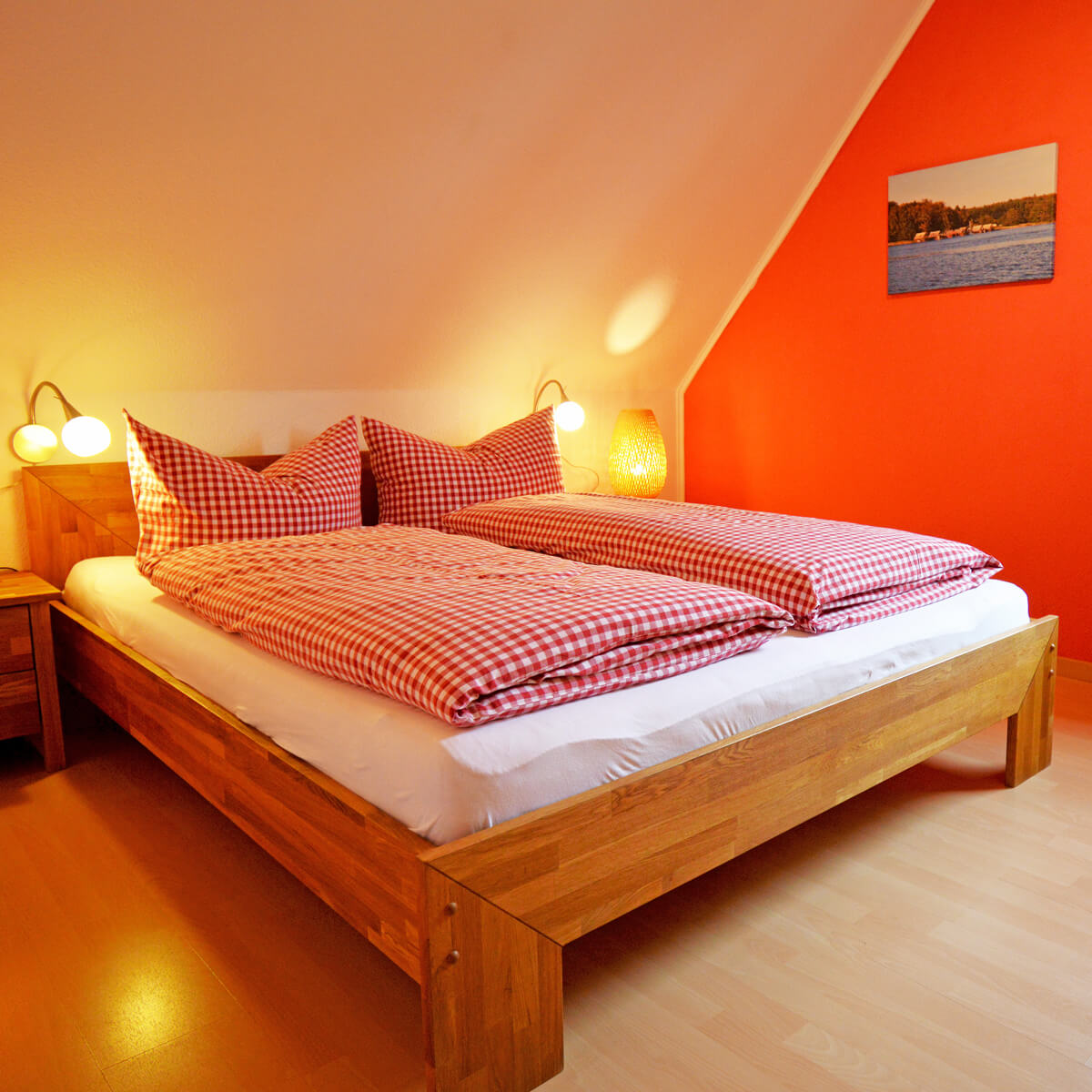 Gemütliches Schlafzimmer im Ferienhaus Fox Zislow mit Doppelbett und roter Wandgestaltung