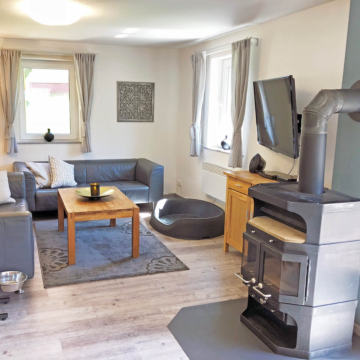 Wohnzimmer im Ferienhaus Fox Zislow mit Kaminofen, Sofa und Hundebett